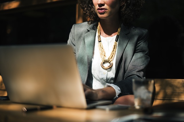 Una autónoma escribiendo en su computador las diferencias entre las actividades empresariales y profesionales