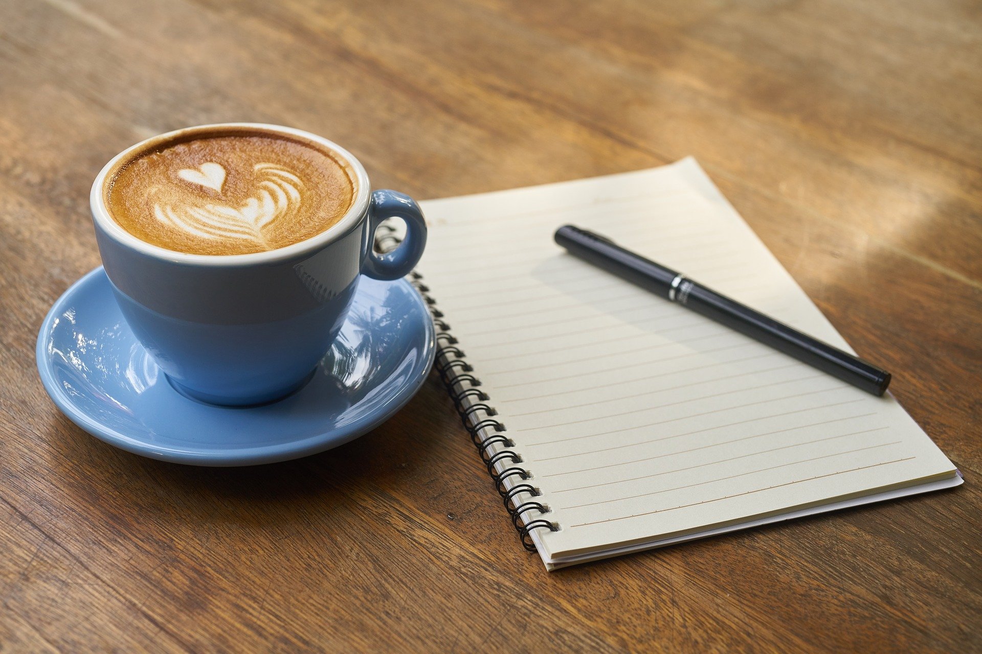 un café, una libreta y un boli para apuntar los tramos de IRPF del autónomo