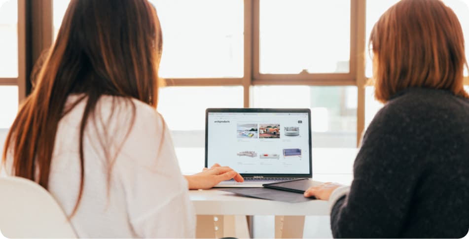 Dos autónomas mirando en un ordenador cómo hacer un ecommerce