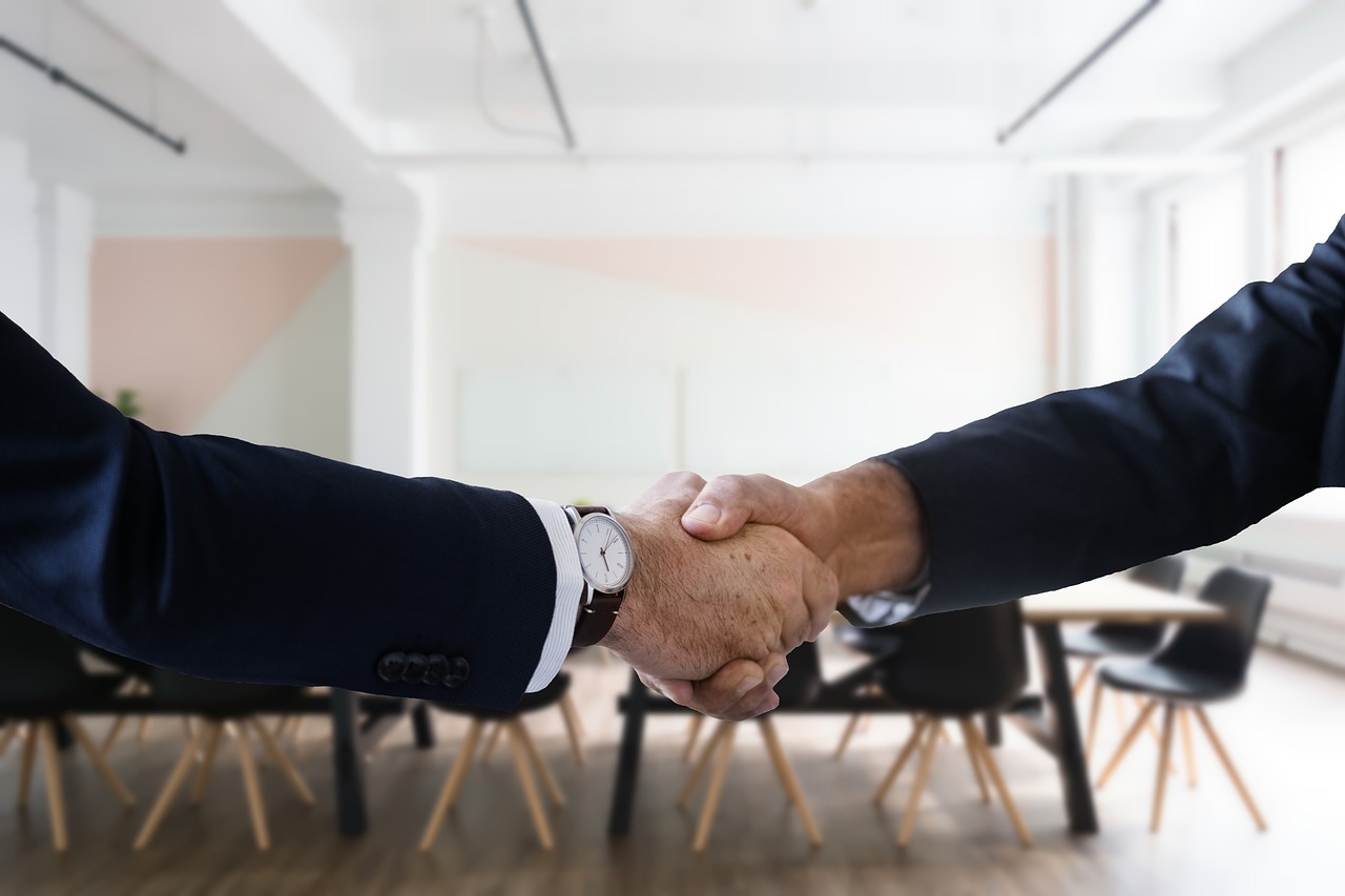 Dos personas estrechándose la mano en la oficina por contratar a un trabajador autónomo