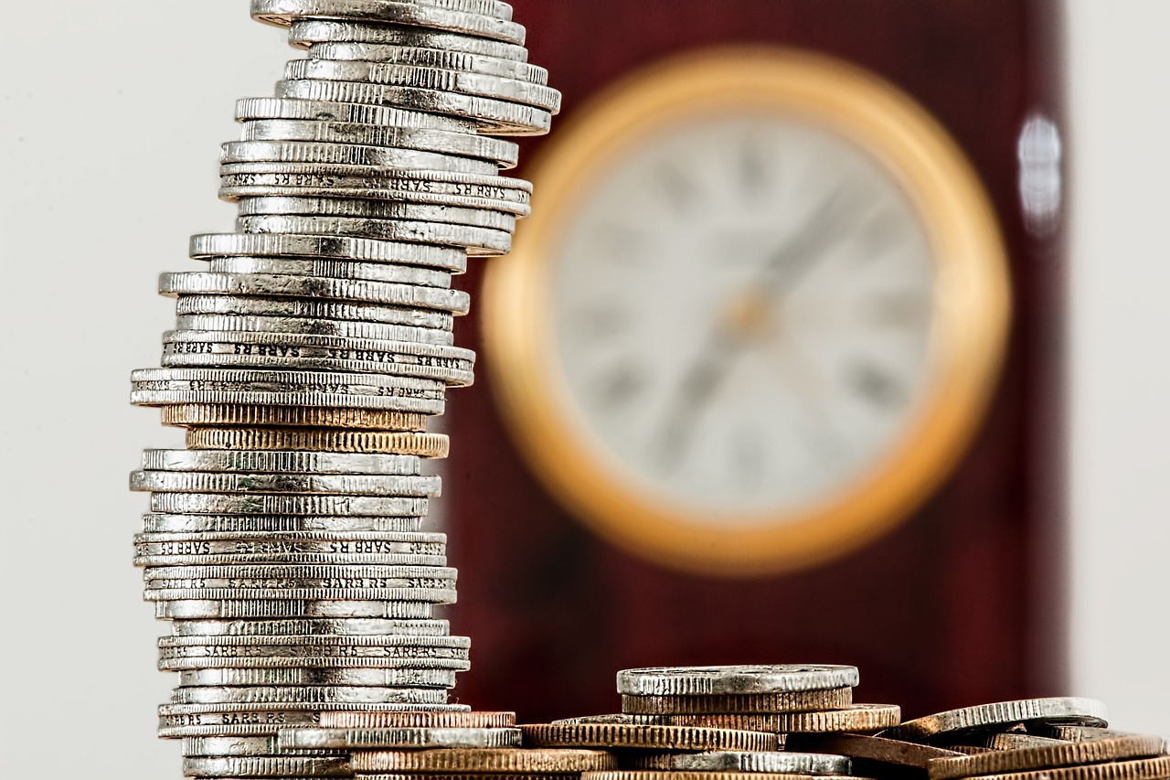 Dinero y un reloj que ejemplifican cuánto tardará hacienda en devolver el dinero